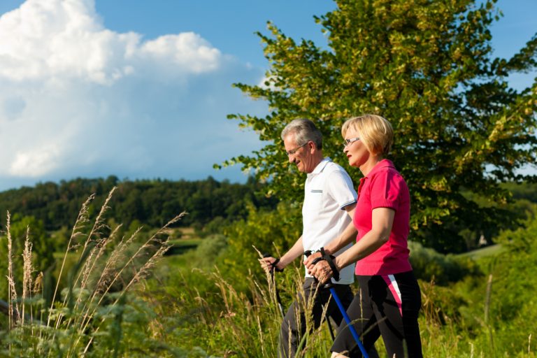 Un couple pratique la marche nordique en pleine nature